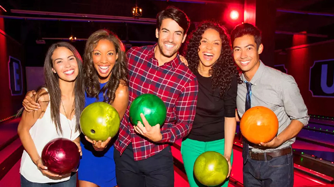 People Holding Bowling Balls at a Bowling Alley