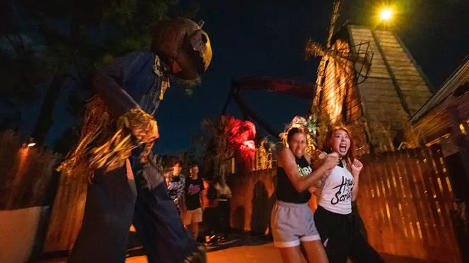 People running from a Scarecrow at Howl O Scream Event