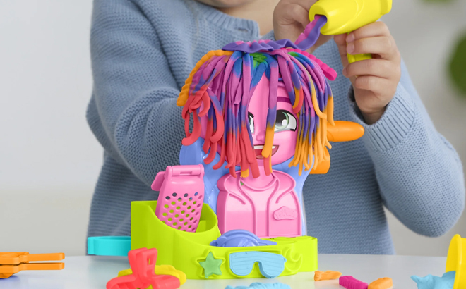 A Child Playing With The Play Doh Hair Stylin Salon Playset