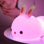 A Child Sleeping and a Kids Bunny Night Light on a Table