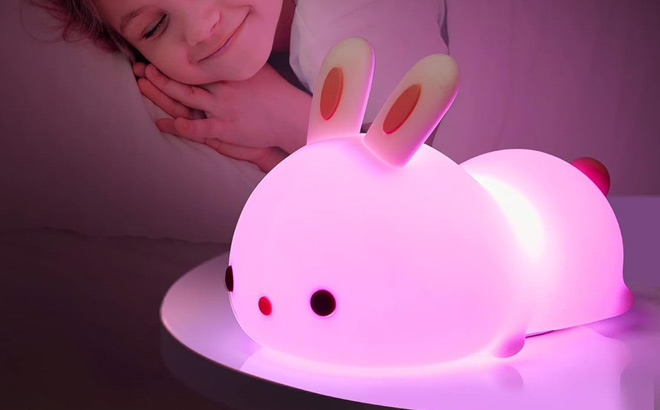 A Child Sleeping and a Kids Bunny Night Light on a Table