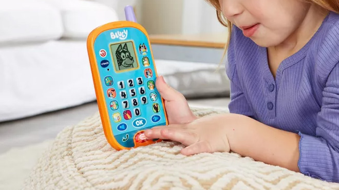 A Girl Holding the VTech Bluey Ring Ring Phone