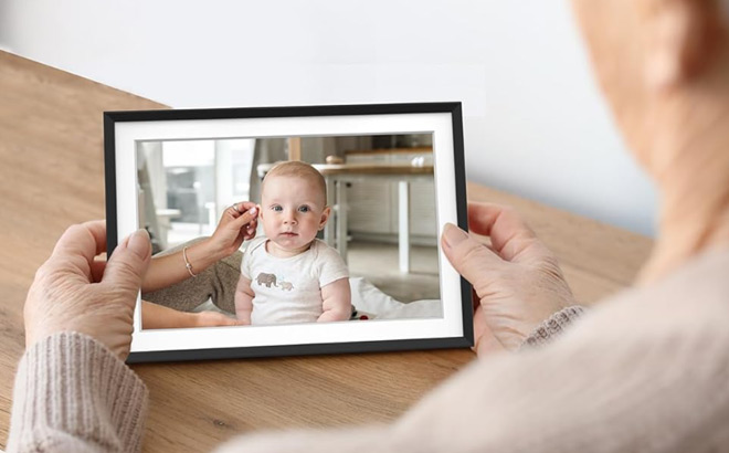 A Grandmother Looking at Her Grandchild on a Digital Picture Frame