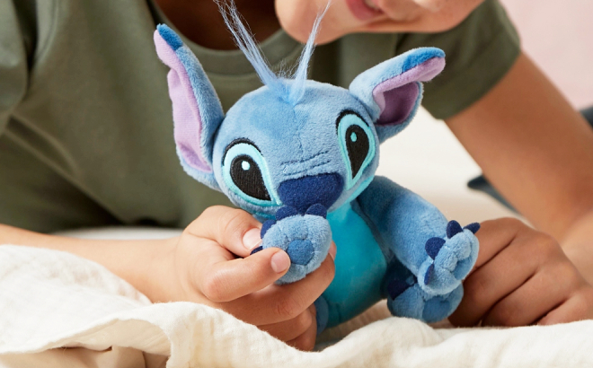 A Kid Holding a Disney Stitch Plush