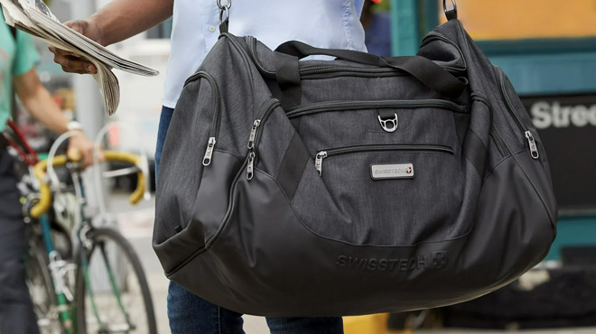 A Man Holding SwissTech Gray Excursion 28 Inch Travel Duffel