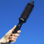 A Person Holding Amika Blowout Babe Thermal Round Brush