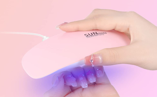 A Person Holding Mini Gel Nail Lamp in Pink Color