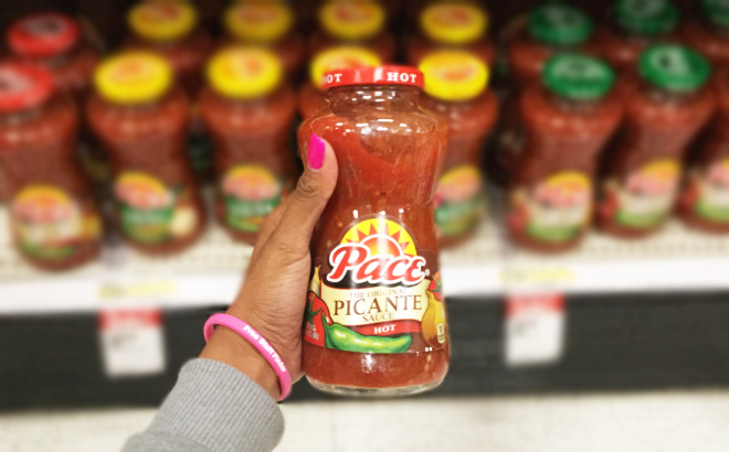 A Person Holding Pace Hot Picante Sauce