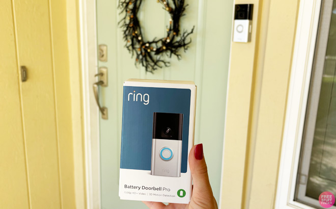 A Person Holding Ring Battery Doorbell Pro in Front of the Door