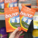 A Person Holding Two Boxes of Bounce Dryer Sheets