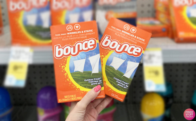 A Person Holding Two Boxes of Bounce Dryer Sheets