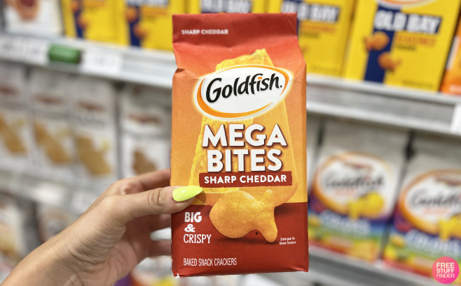 A Person Holding a Bag of Goldfish Mega Bites Sharp Cheddar Crackers