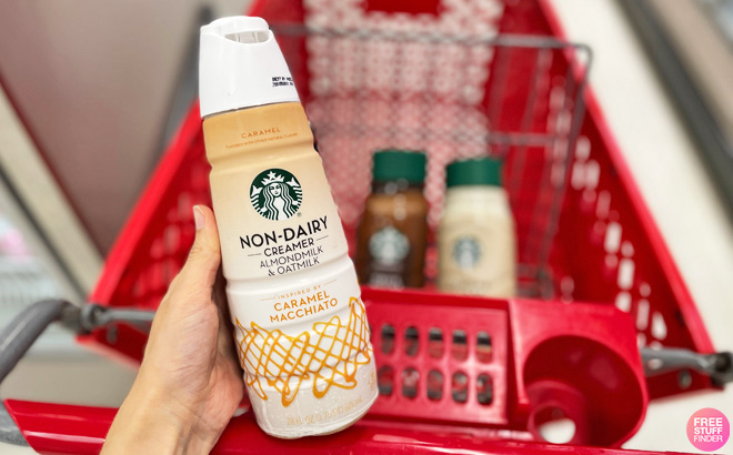 A Person Holding a Starbucks Almond Milk and Oat Milk Caramel Macchiato Coffee Creamer