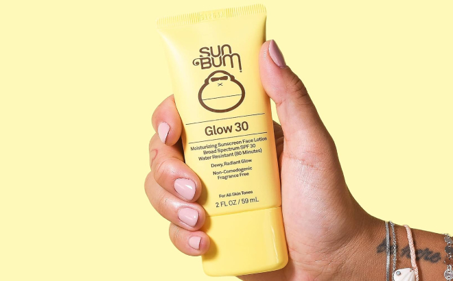 A Person Holding a Sun Bum Original SPF 30 Glow Sunscreen