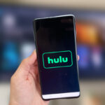 A Person Showing a Mobile Phone with Hulu Logo on It