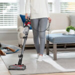 A Person Using a Bissell Cleanview Pet Slim Stick Corded Vacuum