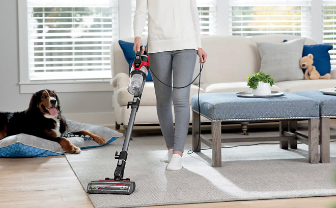 A Person Using a Bissell Cleanview Pet Slim Stick Corded Vacuum