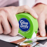 A Person Using a Glue Dots Dot N Go Dispenser