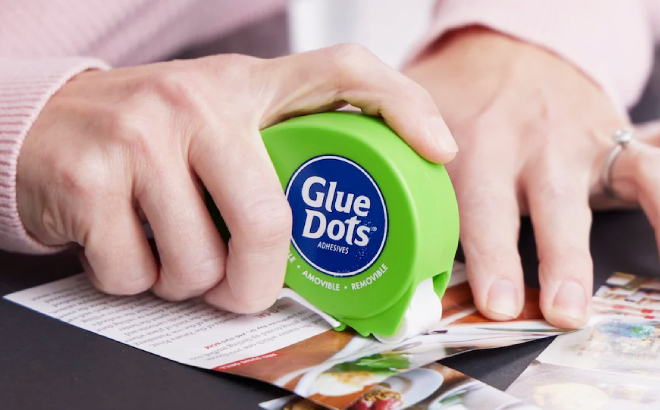 A Person Using a Glue Dots Dot N Go Dispenser