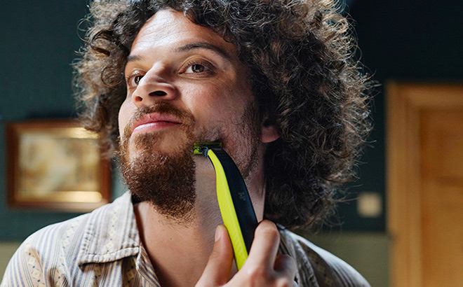 A Person Using a Philips Electric Trimmer Shaver