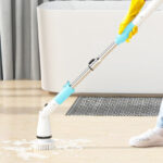 A Person Using an Electric Spin Scrubber to Clean the Floot