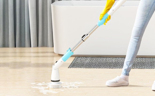 A Person Using an Electric Spin Scrubber to Clean the Floot