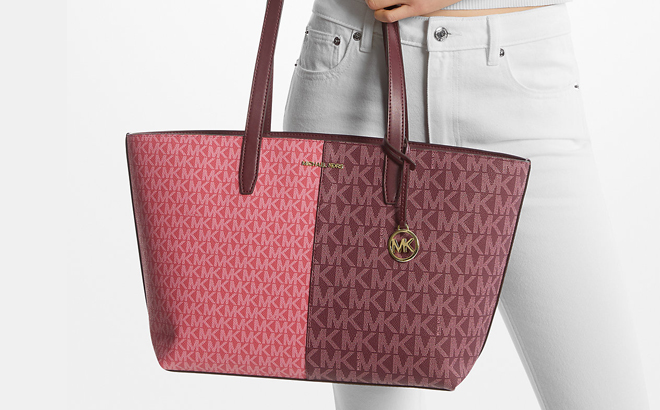 A Person holding a Michael Kors Jet Set Medium Two Tone Logo Tote Bag