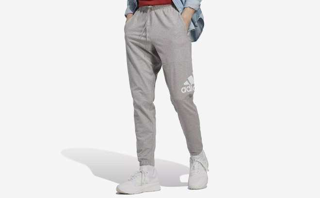 A Person wearing Adidas Mens Essentials Jersey Tapered Pants