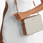 A Person wearing Michael Kors Large Printed Logo Crossbody Bag