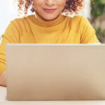 A Smiling Woman Working on a Laptop