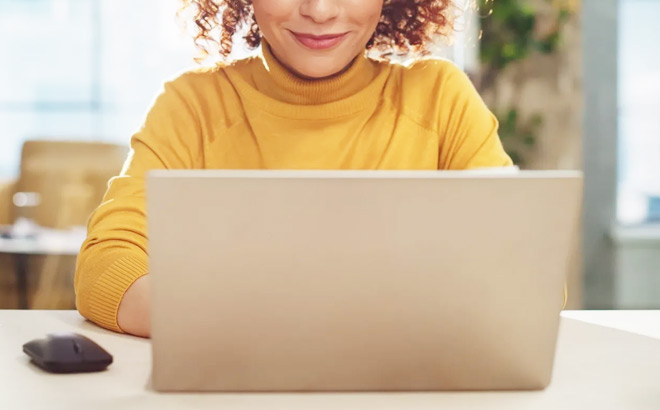 A Smiling Woman Working on a Laptop