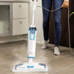 A Woman Cleaning the Floors with Bissell PowerFresh Deluxe Pet Scrubbing Steam Mop with SpotBoost Brush