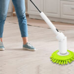 A Woman Cleaning the Kitchen Floors with an Electric Spin Scrubber