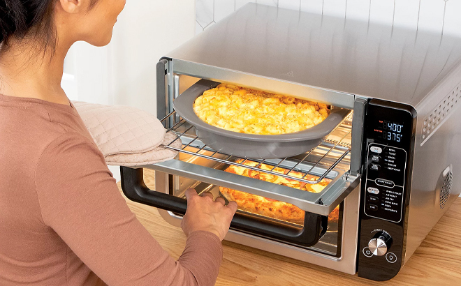 A Woman Cooking with the Ninja 12 in 1 Rapid Cook Convection Double Oven