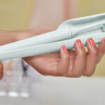 A Woman Holding Philips One by Sonicare Battery Toothbrush