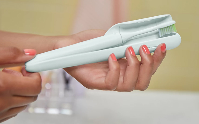 A Woman Holding Philips One by Sonicare Battery Toothbrush