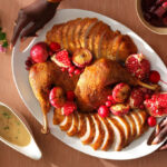 A Woman Serving the Thanksgiving Dinner on a Table