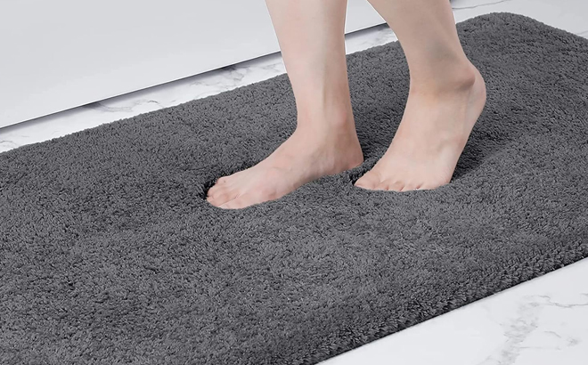 A Woman Stepping on the Buganda Bathroom Rug Mat