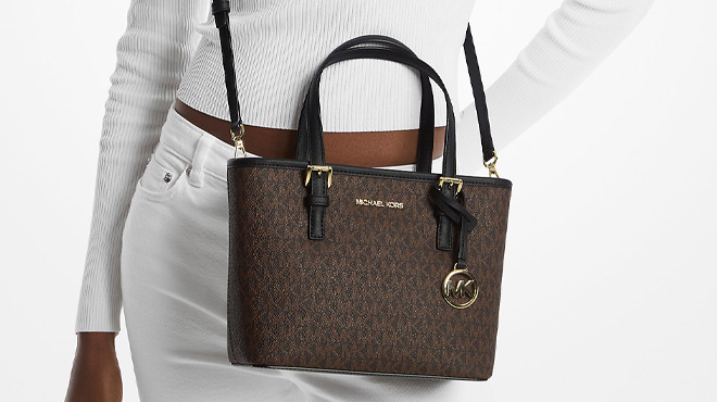 A Woman Wearing Michael Kors Jet Set Travel Extra Small Logo Top Zip Tote Bag