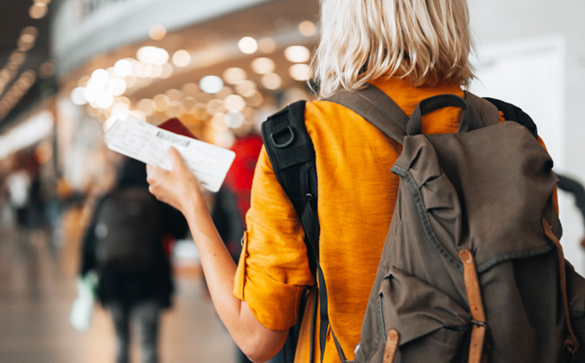 A Woman with a Backpack and Tickets for Traveling