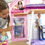 A child playing with Barbie Malibu Dollhouse