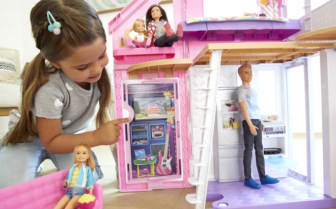 A child playing with Barbie Malibu Dollhouse