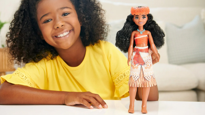 A girl playing with Disney Princess Moana 11 Fashion Doll