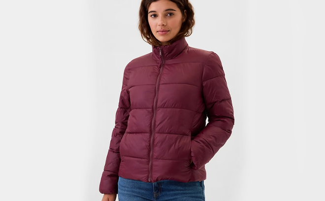 A lady wearing GAP Factory Womens ColdControl Puffer Jacket in burgundy pinot noir color 1