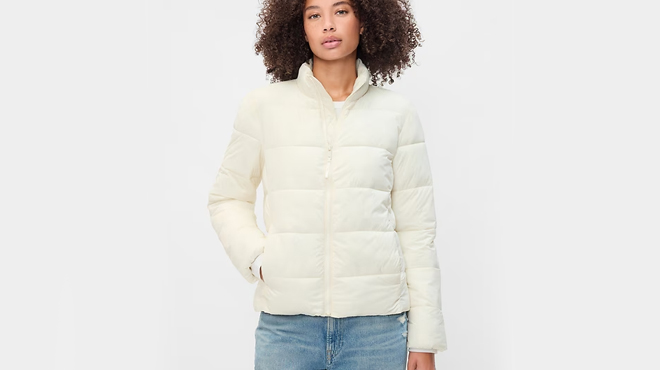 A lady wearing a GAP Factory Womens ColdControl Puffer Jacket in ivory cream frost