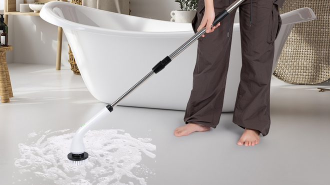 A person cleaning a bathroom floor using Uranzl Electric Spin Scrubber