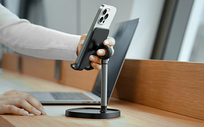 A person holding her phone that is mounted on a Lisen Desk Phone Stand