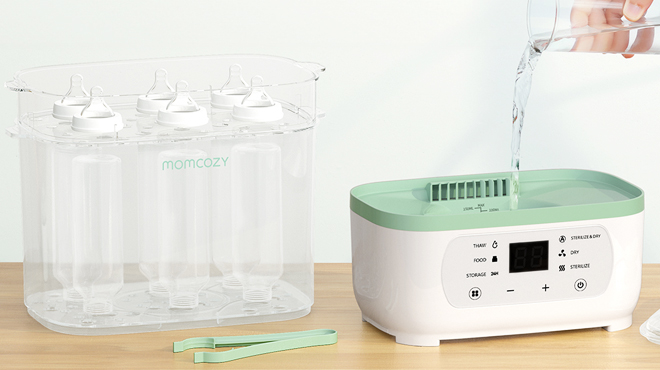 A person puring a glass of water on the Momcozy Bottle Sterilizer Dryer to steam clean feeding bottles