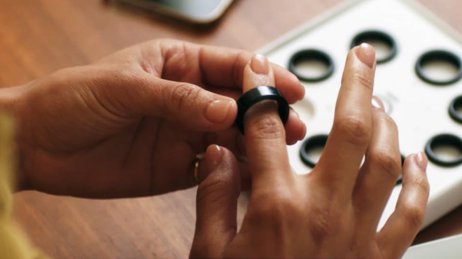 A person sizing his finger using an Oura Ring Gen3 Sizing Kit