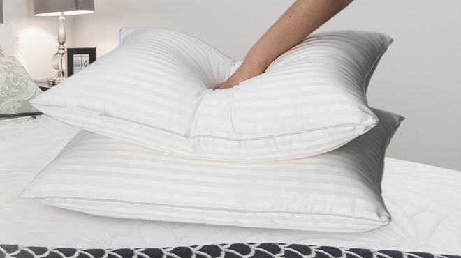 A person squeezing Qnoon Hotel Collection 2 pk Bed Pillows